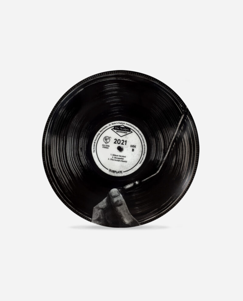 Black ceramic 2021 Year Plate with vinyl record design showing hand and white centre label marked SIDE B by The Sculpts