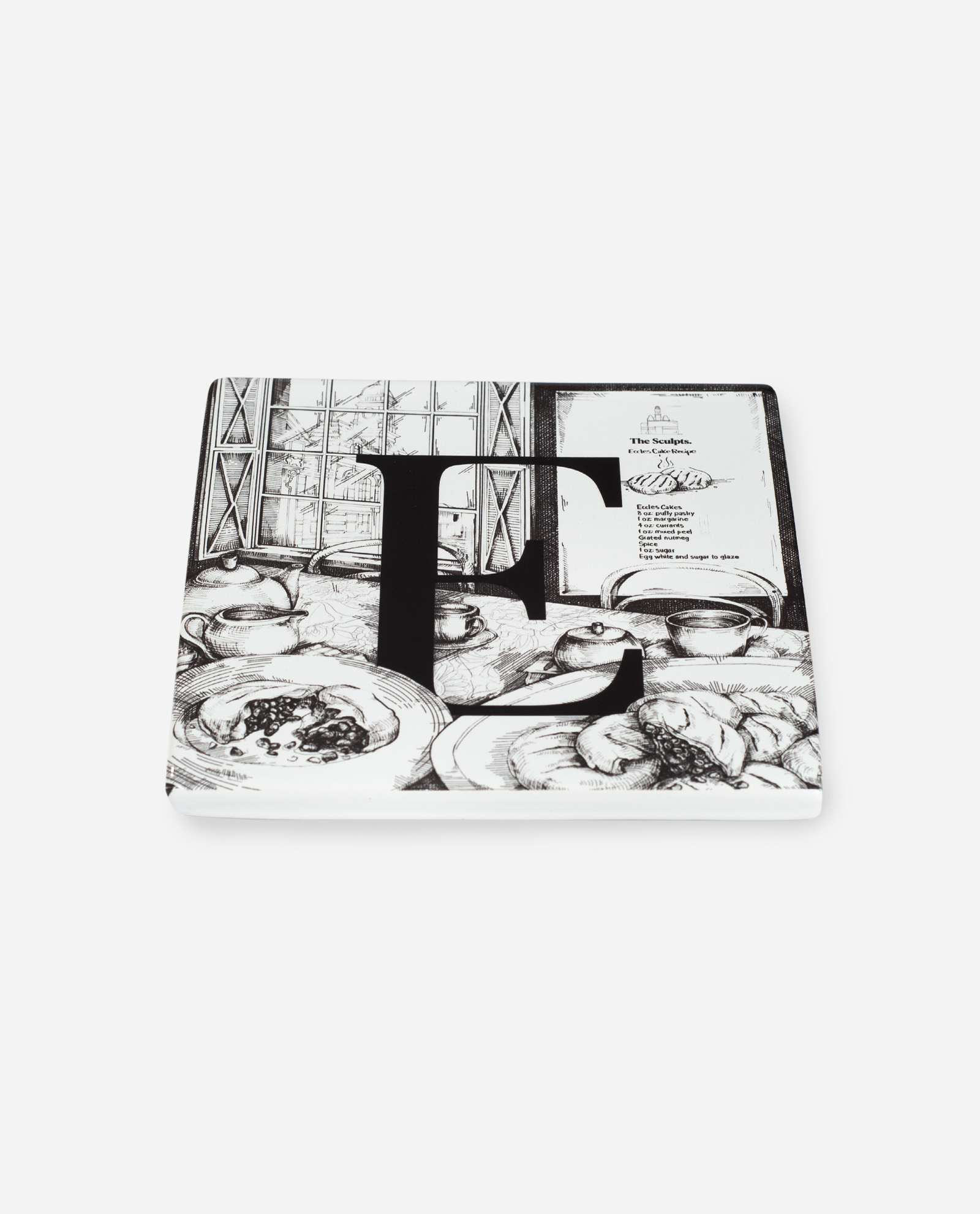 Angled view of white ceramic Manchester E tile with Eccles cake illustration showing dimensional glazed surface