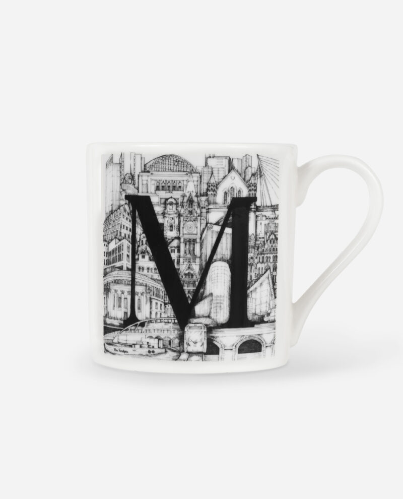 Manchester Letter M Mug front view showing large black letter M filled with detailed pen drawing of Manchester buildings and landmarks