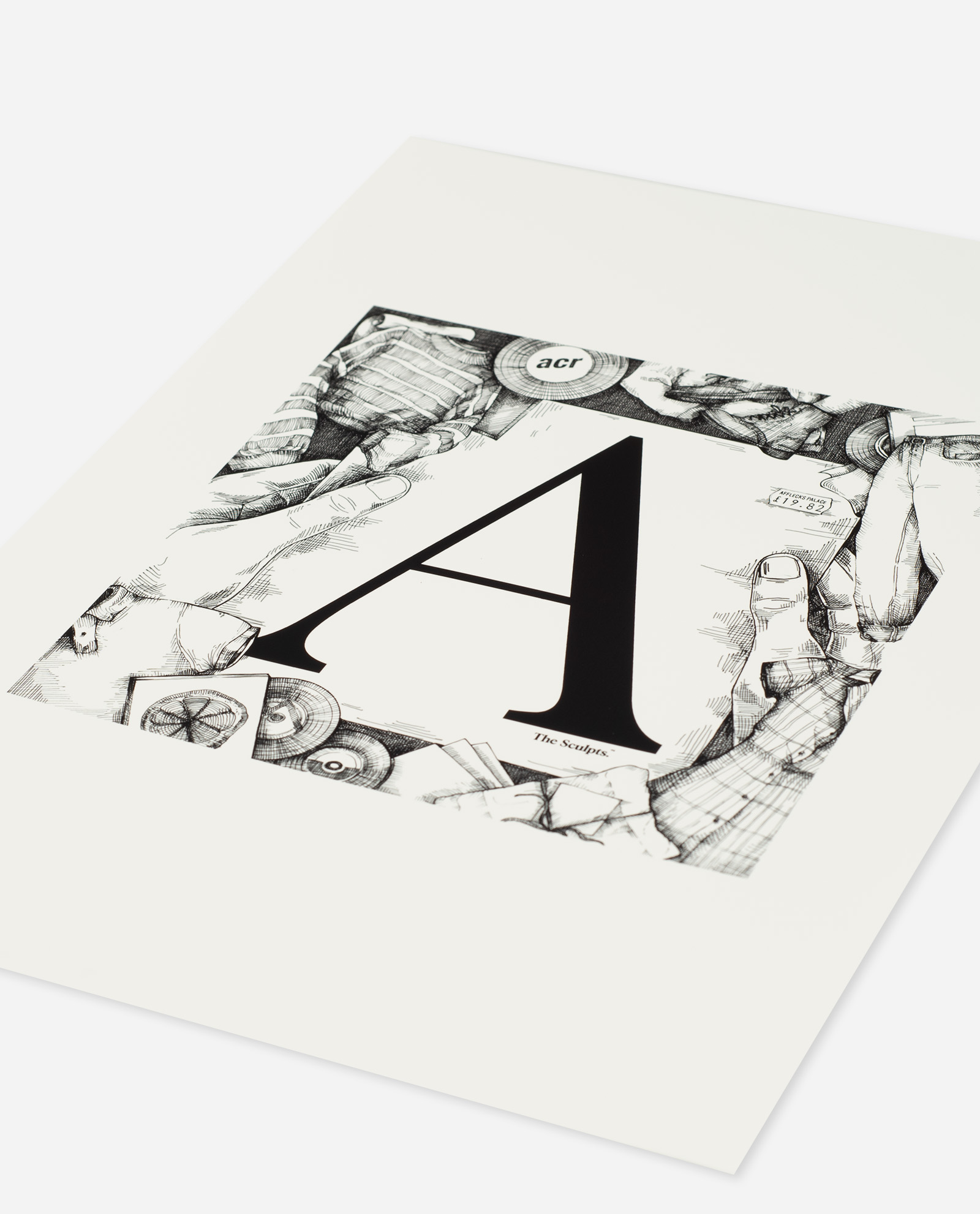 Oblique angle view of Affleck's Palace Manchester Letter A print showing bold black typography with illustrated border of hands, records and alternative culture objects on white paper