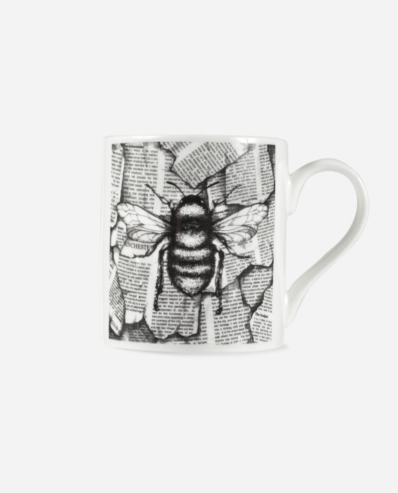 Manchester Bee Coffee Mug front view showing detailed black worker bee illustration over newspaper text collage on white bone china