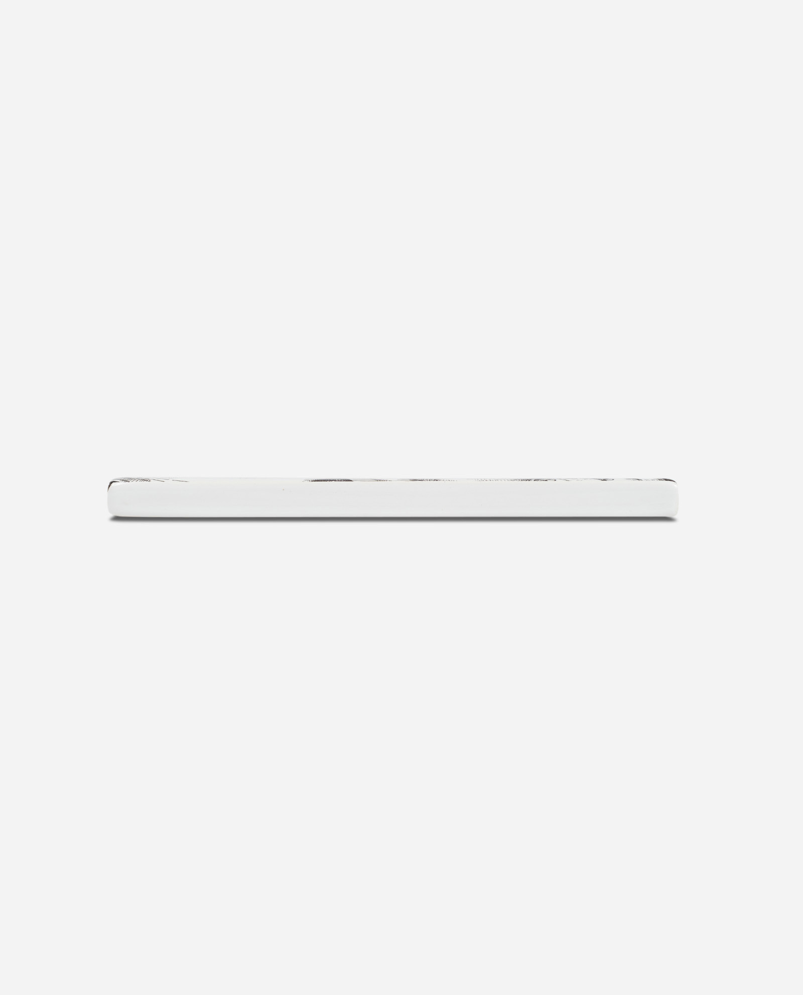 Side profile of white ceramic Eccles cake tile showing slim 6 inch square edge against plain background