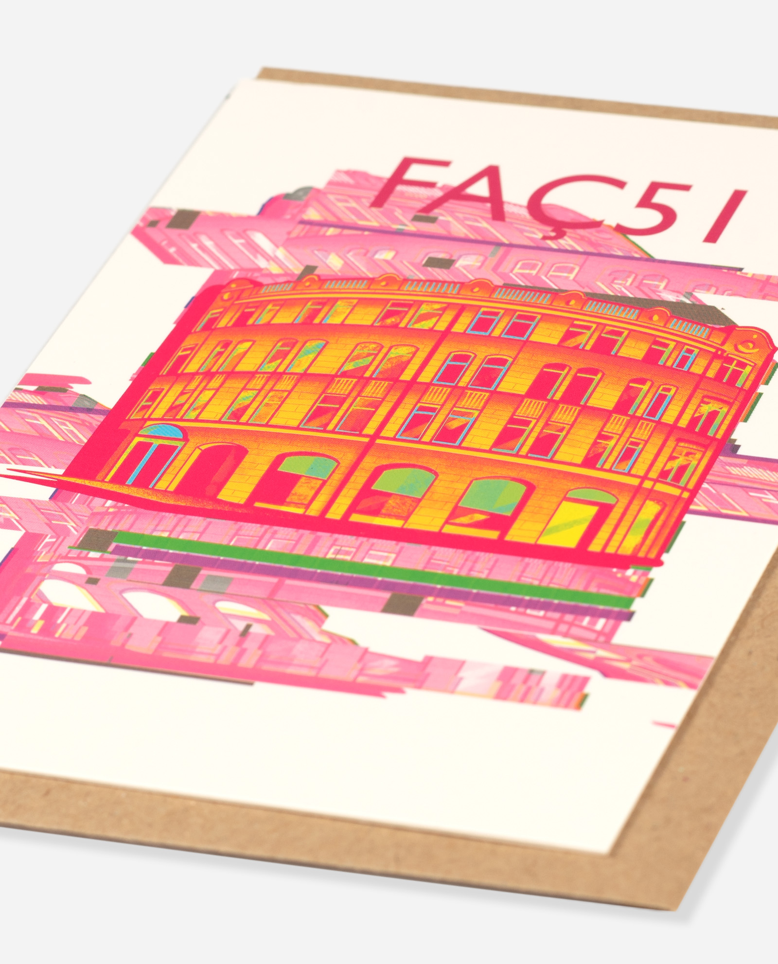 Faç51 greeting card shown at an angle displaying neon orange Hacienda building design with pink glitch stripes and green base detail on cream paper