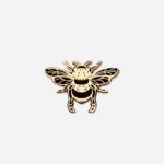 Manchester Bee Pin Badge in gold enamel with black detailing, showing intricate wing veins and striped body, front view