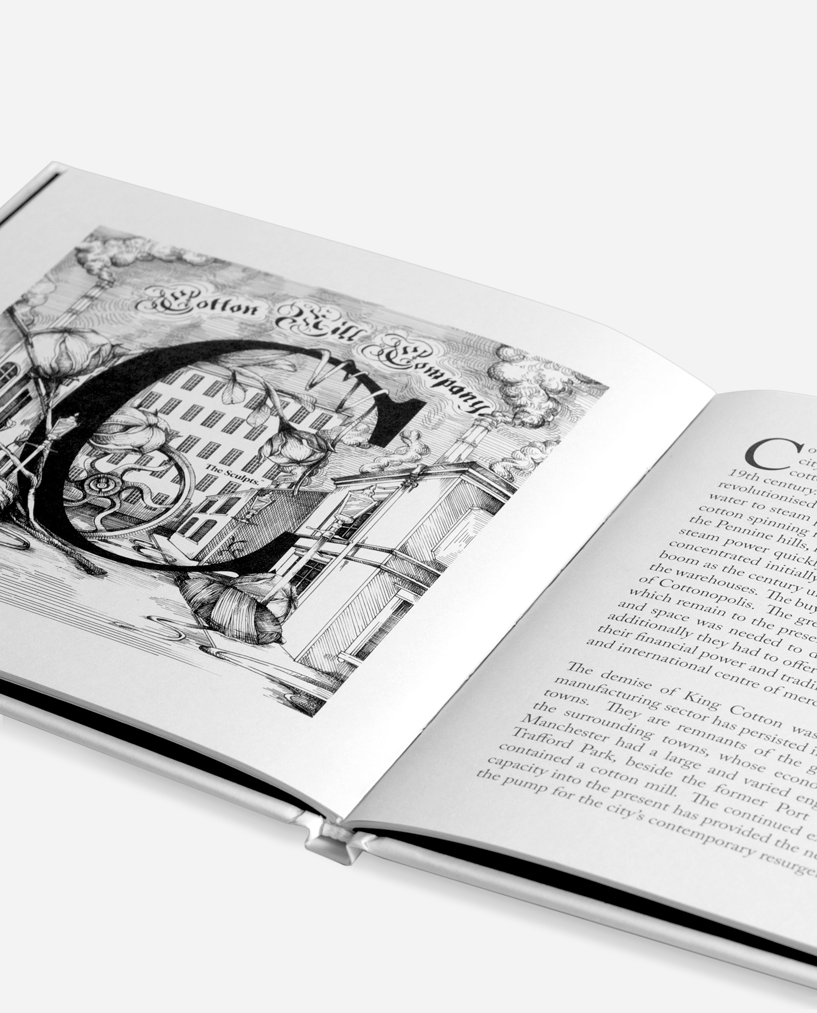 Manchester book photographed at angle showing hardback binding, letter C page visible with Cotton Mill Company illustration featuring industrial buildings and canal scene