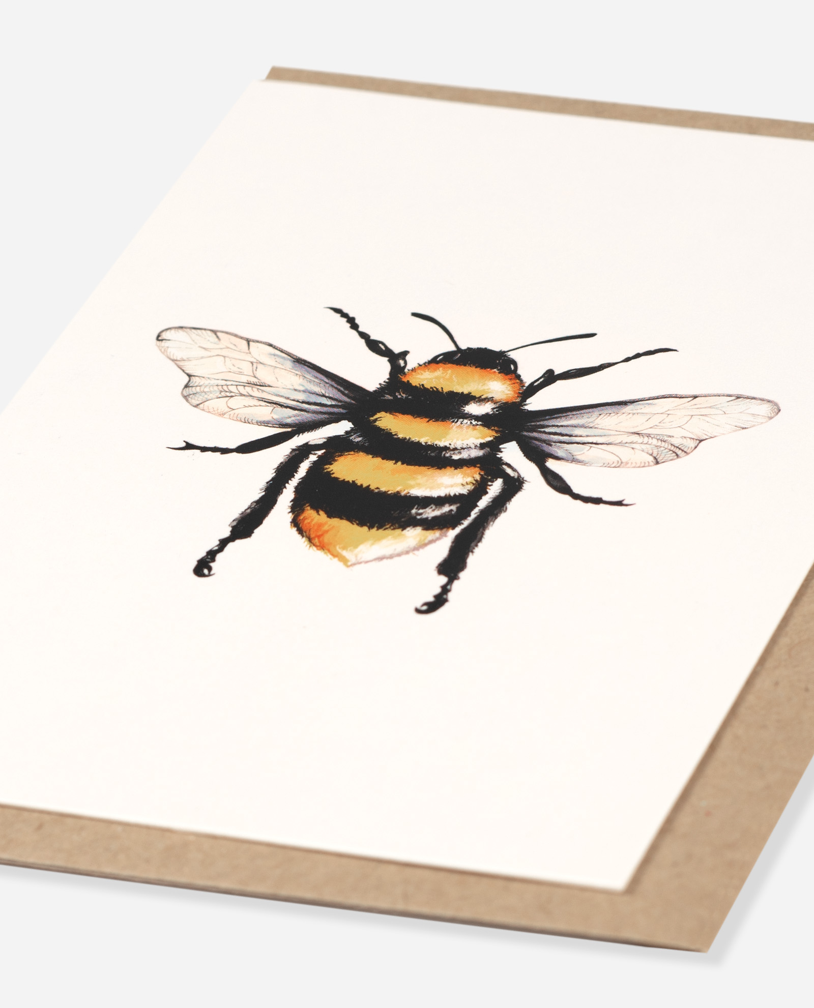 Close-up angled view of Manchester Bee Greeting Card showing detailed watercolour bee with black and orange stripes