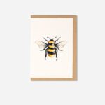 Manchester Bee Greeting Card showing watercolour bumblebee design on cream card with kraft envelope, flat lay view