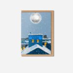 Sankey's Soap Christmas card flat lay showing blue Beehive Mill with snow, disco ball and yellow windows by The Sculpts