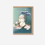 Cotton Snowman Christmas Card showing white fluffy snowman with orange carrot nose beside Manchester and North Pole signpost on teal background