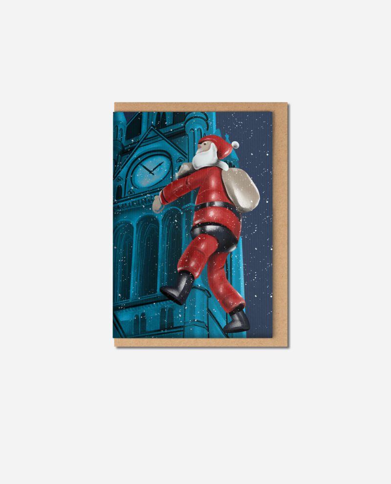 Town Hall Santa Christmas card by The Sculpts showing red inflatable Santa climbing blue Manchester Town Hall with kraft envelope