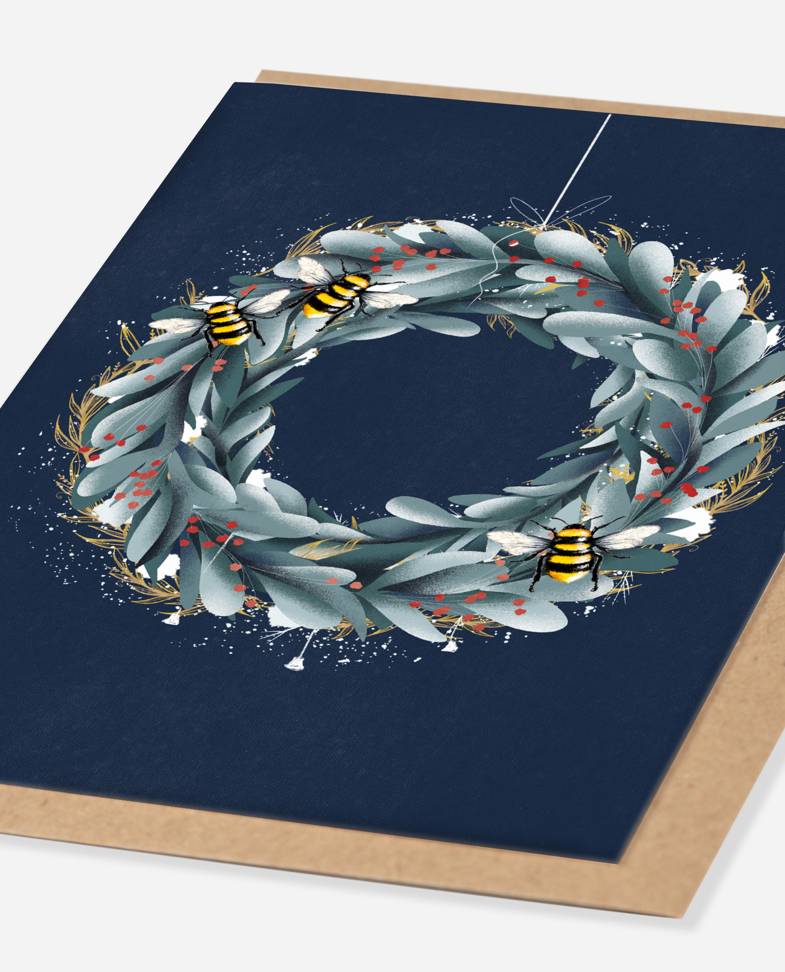 Angled view of Christmas wreath card showing sage leaves, red berries, bees and white splatter details on navy card