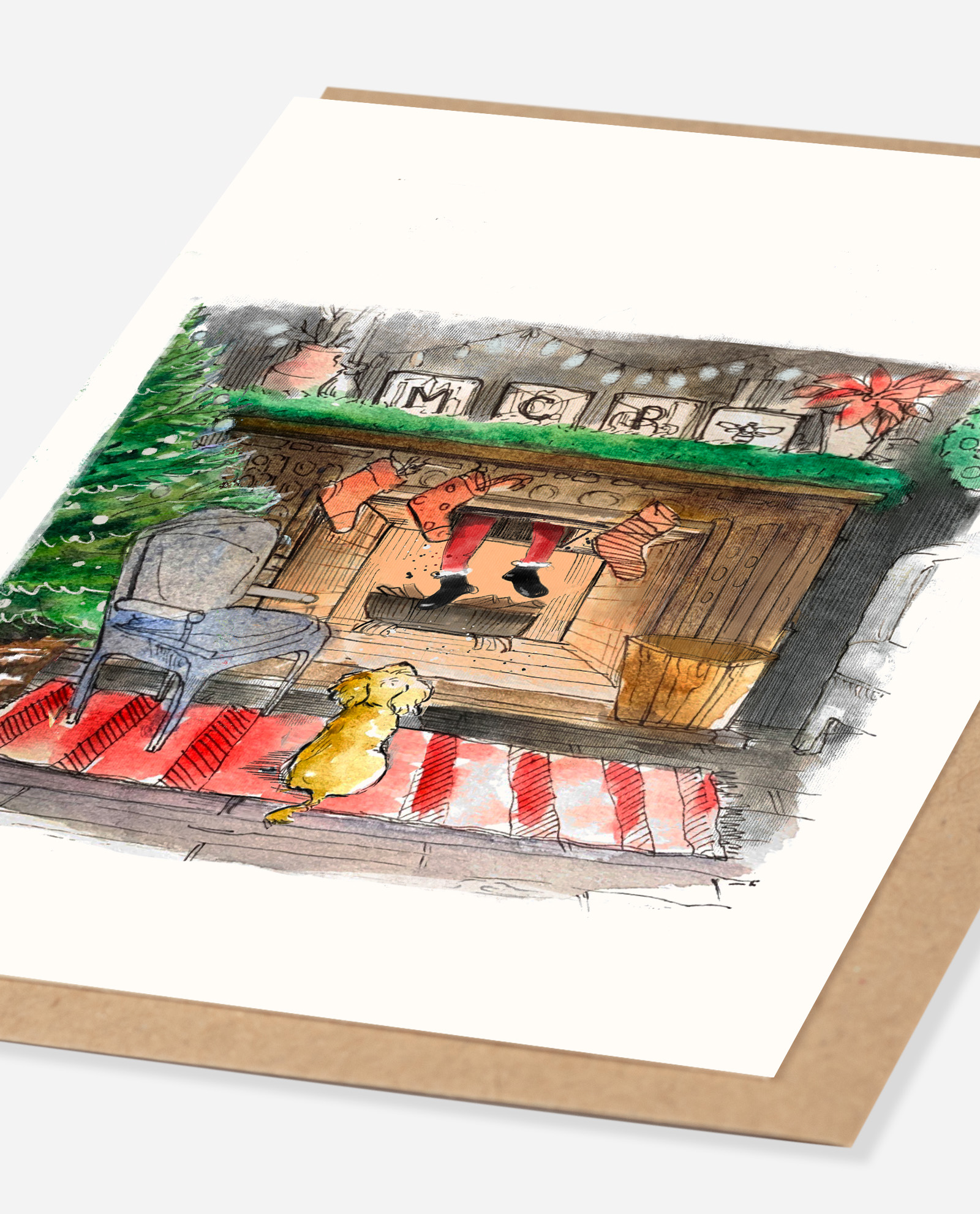 Angled view of cockapoo Christmas greeting card on Kraft envelope showing watercolour fireplace illustration detail