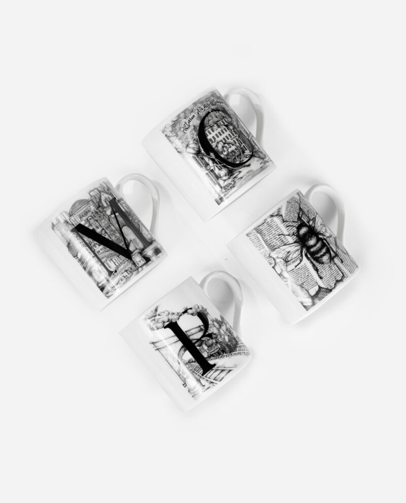 Four white Manchester mugs arranged in grid showing black illustrations of MCR landmarks and bee on fine bone china by The Sculpts