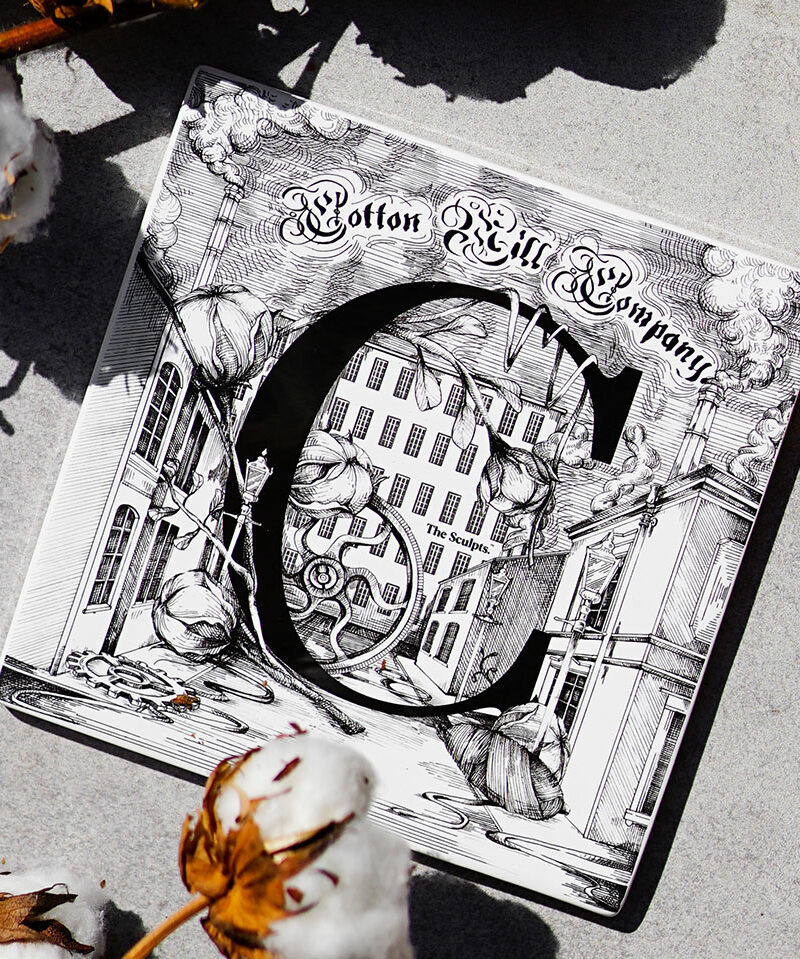 Cotton Mill Company ceramic tile with ornate C letter, architectural buildings and cotton plant illustrations in black on white