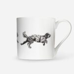 Dog running mug with black cockapoo illustration mid-leap on white bone china, side view showing curved handle