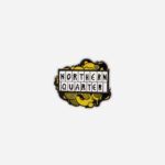 Northern Quarter pin badge in yellow and black enamel with hatched pattern background and white letter tiles by The Sculpts