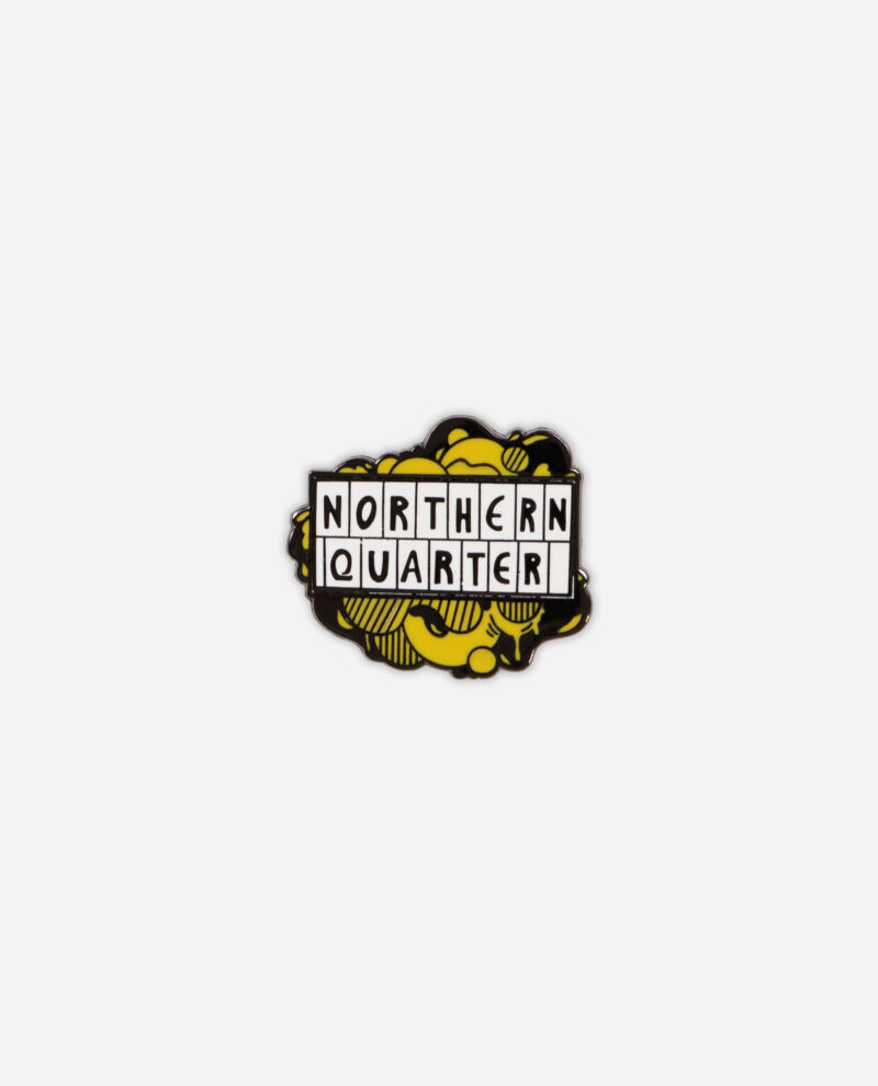 Northern Quarter pin badge in yellow and black enamel with hatched pattern background and white letter tiles by The Sculpts