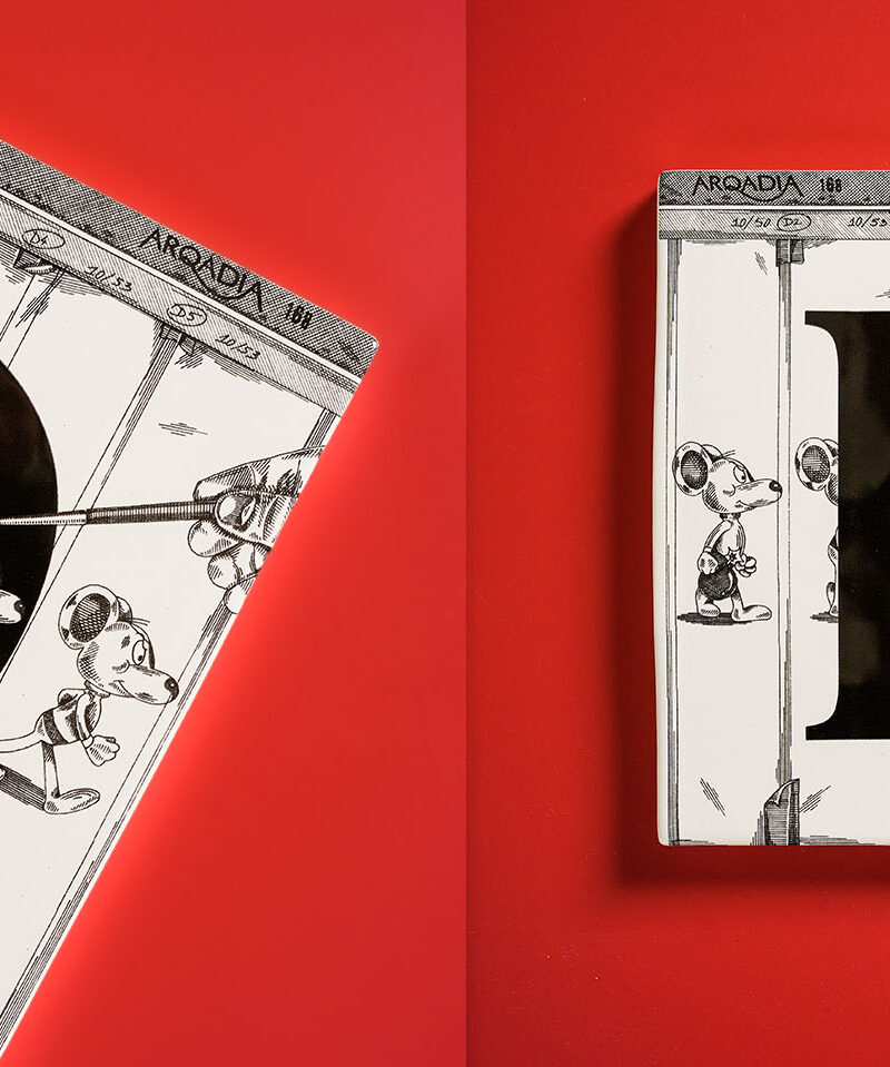 Square ceramic tile with black D letter and vintage animation cells showing Danger Mouse characters on strings with 'Arcadia 188' text at top