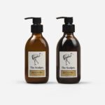 Honeycomb Bee hand wash and lotion set in amber glass bottles with black pumps and cream labels featuring bird illustration