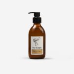 Honeycomb Bee Hand Lotion amber glass bottle with black pump dispenser showing elegant bird illustration and product label