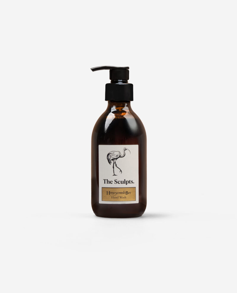 The Sculpts Honeycomb Bee Hand Wash amber bottle with black pump dispenser showing cream label